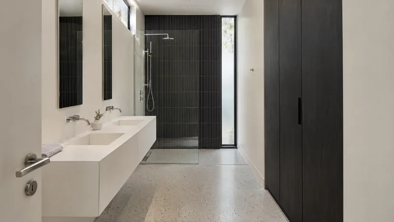graphic monochrome bathroom design concept: Ink tiles, white stone, polished chrome, courtyard light
