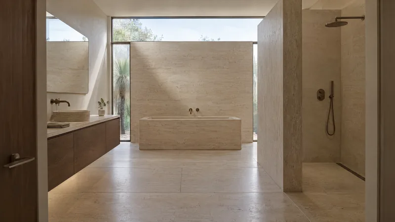 sculpted travertine bathroom design concept: Vein-cut travertine, walnut, clerestory daylight
